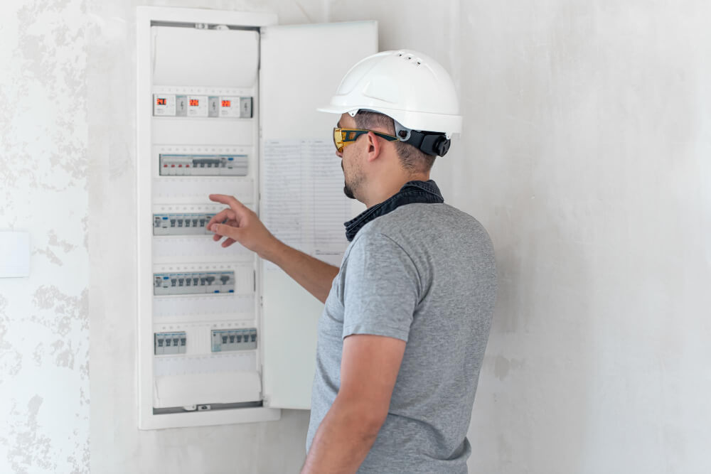 Technician securing circuit breaker lockout device during maintenance.